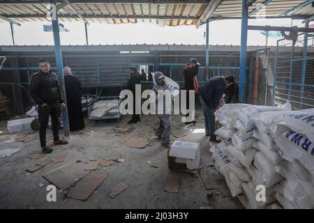 Città di Gaza, territori palestinesi. 16th Mar 2022. I palestinesi raccolgono aiuti alimentari da un centro di distribuzione gestito dall'Agenzia delle Nazioni Unite per il soccorso e l'occupazione (UNRWA). I prezzi dei prodotti alimentari a Gaza City sono saliti dopo l'invasione russa dell'Ucraina. Alcuni rifugiati vendono l'aiuto alimentare, che comprende farina, olio da cucina, riso, lenticchie e latte; per garantire i soldi per la loro vita. Credit: Mohammed Talatene/dpa/Alamy Live News Foto Stock