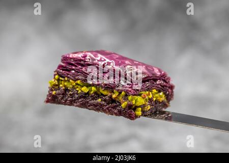 Pistacchio baklava viola (baklava viola). Sapori tradizionali del Medio Oriente. Nome locale Mor Baklava. Primo piano. Foto Stock