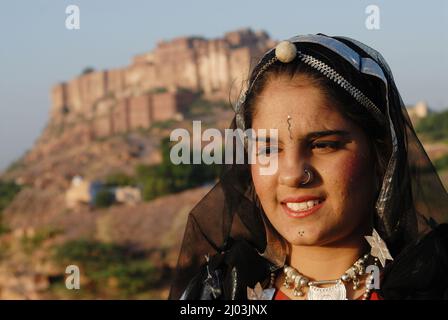Jodhpur; Rajasthan; India; Asia; Oct, 07, 2006 - Unidentified Rajasthani Folk Dancer in abiti tradizionali e gioielli di fronte al forte mehrangarh Foto Stock