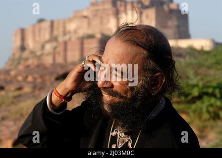 Jodhpur; Rajasthan; India; Asia; Oct, 07, 2006 - Rajasthani rajput uomo ballerini popolari in abito tradizionale parlando su mobile di fronte al forte mehrangarh Foto Stock
