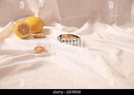 Vita morta minimalista di limoni freschi e secchi che mostrano il concetto di freschezza, estetica estiva e vita sana e sostenibile Foto Stock