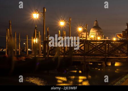 Piccolo molo di Venezia di notte, con gondole e la Basilica di Santa Maria della Salud Foto Stock