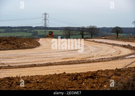 Wendover, Aylesbury, Regno Unito. 15th marzo 2022. HS2 stanno costruendo un'altra strada di trasporto per i loro autocarri attraverso l'ex terreno agricolo a Little Hunts Green Farm e Grim's Ditch un antico monumento programmato, parte del quale è stato distrutto entro il HS2. Un enorme viadotto sarà costruito entro il HS2 da dove il treno uscirà dal tunnel al Portale Nord a South Heath, Great Missenden attraverso la valle attraverso Wendover. La controversa costruzione della ferrovia ad alta velocità del HS2 da Londra a Birmingham è già ampiamente in eccesso di budget. Credit: Maureen McLean/Alamy Foto Stock