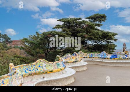 PARK GUELL BARCELLONA CATALOGNA SPAGNA TERRAZZA CENTRALE GAUDI TRENCADIS GIALLO BLU E VERDE MOSAICI SU POSTI A SEDERE A SERPENTINA Foto Stock