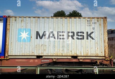 Viersen, Germania - Marzo 9. 2022: Vista sul treno a destra con un contenitore di carico della compagnia di navigazione Maersk Foto Stock