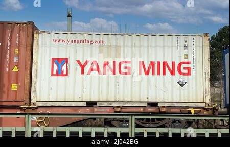 Viersen, Germania - Marzo 9. 2022: Vista sul treno a destra con contenitore di carico della società di trasporto marittimo di Yang Ming Foto Stock