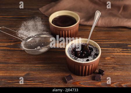 Ramekins con gustosi dolci di lava su sfondo di legno Foto Stock