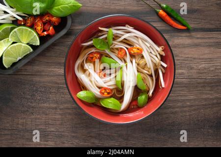 Vista dall'alto di una ciotola di pho vietnamita in una ciotola rossa Foto Stock