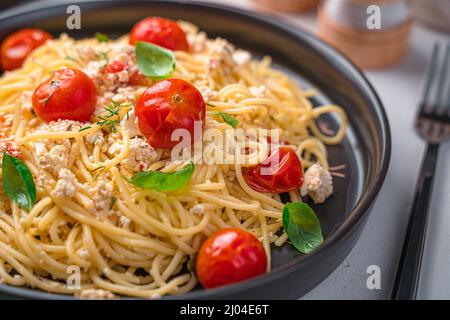 Primo piano pasta con feta, pomodori ciliegini, erbe e basilico. Fetapasta. Foto Stock