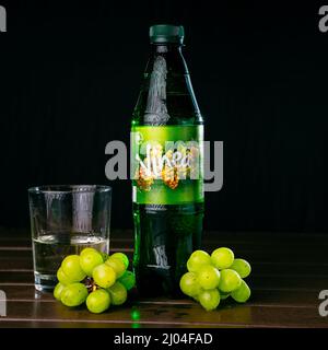 Soda con uva e bicchiere sul tavolo Foto Stock