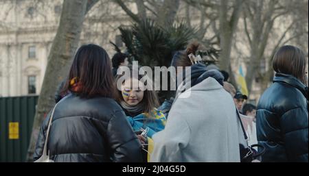 Londra, UK - 03 06 2022: Una giovane donna ucraina che ha protestato su Parliament Square, con strisce blu e gialle dipinte sulla guancia. Foto Stock