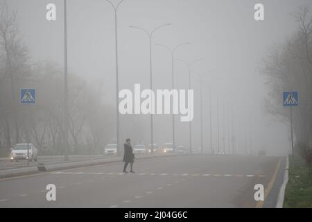 Tashkent, Uzbekistan. 16th Mar 2022. Un cittadino attraversa una strada in mezzo alla nebbia fitta a Tashkent, Uzbekistan, 16 marzo 2022. Credit: CAI Guodong/Xinhua/Alamy Live News Foto Stock