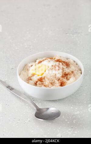 budino di riso con cannella al burro, riz au lait francese, risgrot norvegese, dessert tradizionale per la colazione Foto Stock