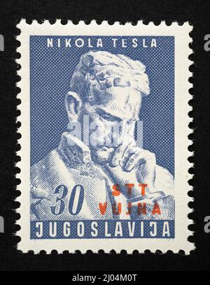 Francobollo celebrativo con l'immagine di Nikola Tesla dell'ex Jugoslavia con la sovrastampa del territorio libero di Trieste, zona B dell'anno 19 Foto Stock