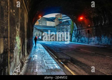 La persona è stata vista da dietro passeggiando attraverso un tunnel oscuro preso a King's Bridge, la stalla strada dei re passa sotto Edimburgo il 27th marzo 2017 Foto Stock