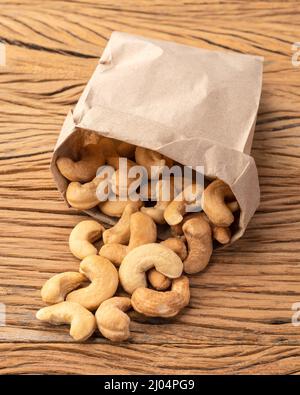 Dadi in un sacchetto di carta su tavola di legno. Foto Stock