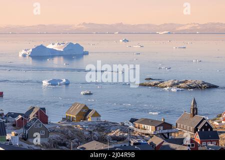tipica città artica circondata da grandi iceberg Foto Stock