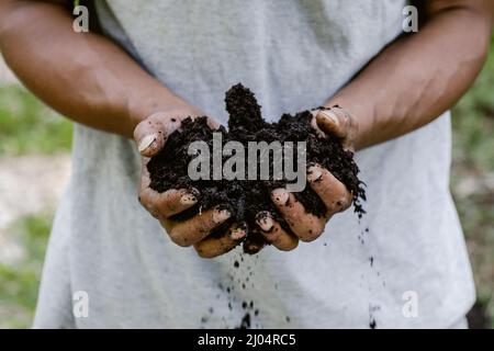 Primo piano di due mani che tengono terreno fresco Foto Stock