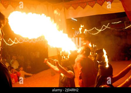 27 2009 settembre Navratri Durga Pooja Dandia raas fuoco su Garba e anello rotondo su testa e ragazza coprì gli occhi con tela nera un uomo che soffia fuoco. Foto Stock