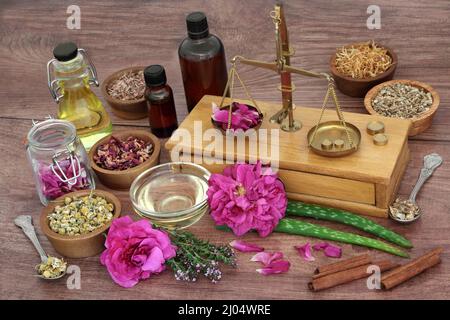 Erbe curative e fiori per la cura naturale della pelle con vecchie bilance in ottone per la preparazione di trattamenti essenziali ad olio. Assistenza sanitaria per aiutare a curare e. Foto Stock