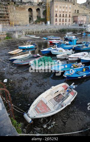 Pozzuoli, Italia. 16th Mar 2022. La darsena dei pescatori nel porto di Pozzuoli rimase quasi priva di acqua di mare per il bradicismo che in questo periodo si intensifica in tutta la zona dei campi Flegrei che si trova sulla più grande caldera d'Europa. Il bradicismo fa lievitare la terra e, in questo caso, le barche dei pescatori sono rimaste asciutte giacendo sulla terra. Credit: Independent Photo Agency/Alamy Live News Foto Stock