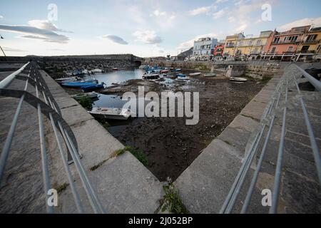 Pozzuoli, Italia. 16th Mar 2022. La darsena dei pescatori nel porto di Pozzuoli rimase quasi priva di acqua di mare per il bradicismo che in questo periodo si intensifica in tutta la zona dei campi Flegrei che si trova sulla più grande caldera d'Europa. Il bradicismo fa lievitare la terra e, in questo caso, le barche dei pescatori sono rimaste asciutte giacendo sulla terra. Credit: Independent Photo Agency/Alamy Live News Foto Stock