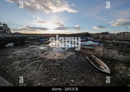 Pozzuoli, Italia. 16th Mar 2022. La darsena dei pescatori nel porto di Pozzuoli rimase quasi priva di acqua di mare per il bradicismo che in questo periodo si intensifica in tutta la zona dei campi Flegrei che si trova sulla più grande caldera d'Europa. Il bradicismo fa lievitare la terra e, in questo caso, le barche dei pescatori sono rimaste asciutte giacendo sulla terra. Credit: Independent Photo Agency/Alamy Live News Foto Stock