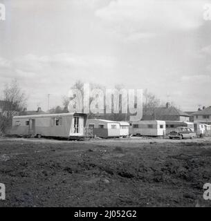 1960s, storico, su un pezzo di derlict terra dietro una certa casa, una lunga roulotte con ruote - più lunga in Inghilterra? - Parcheggiato in uso come casa mobile, Oxford, Inghilterra, Regno Unito. Foto Stock