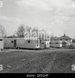 1960s, storico, su un pezzo di derlict terra dietro una certa casa, una lunga roulotte con ruote - più lunga in Inghilterra? - Parcheggiato in uso come casa mobile, Oxford, Inghilterra, Regno Unito. Foto Stock