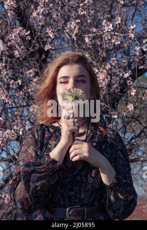 Bella ragazza in primavera parco con fiori. Foto Stock