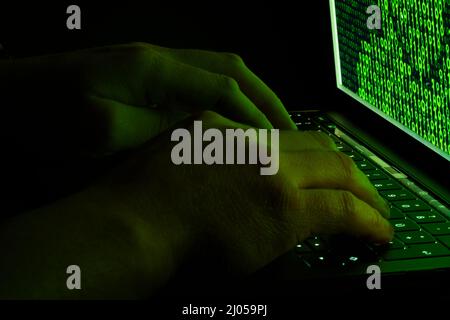 Mani sulla tastiera di un notebook. Concetto di hacker con codice binario. Perdita di dati. Cyber ​​attack. Programmatori software. Foto Stock