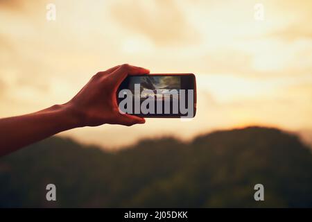 Che punto di vista. Primo piano di un uomo inidentificabile scattando una foto sul suo cellulare esterno. Foto Stock