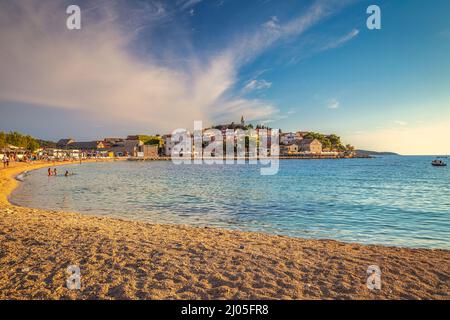 Spiaggia al tramonto vicino a Primosten città, una popolare destinazione turistica sulla costa dalmata del mare Adriatico in Croazia, Europa. Foto Stock