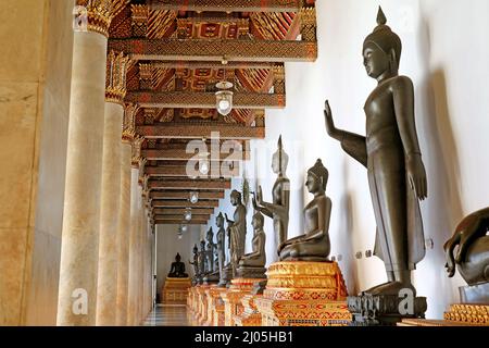 Fila di antiche immagini di Buddha racchiuso nel bellissimo Chiostro di Wat Benchamabophit (il Tempio di marmo), Bangkok, Thailandia Foto Stock