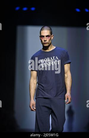 Berlino, Germania. 16th Mar 2022. Berlin Fashion Week: A Kraftwerk Berlin, un modello presenta una creazione del designer ucraino Jean Gritsfeldt. Poiché non può venire a Berlino e la collezione non può essere consegnata, i volontari hanno riadattato i suoi disegni in modo che possano essere mostrati. Credit: Jens Kalaene/dpa-Zentralbild/dpa/Alamy Live News Foto Stock