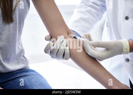Questo non fa male un po'. Un medico che fa un'iniezione ad una donna. Foto Stock