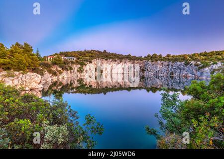 Lo Zmajevo oko, lago Dragon's Eye al tramonto. Il villaggio di Rogoznica, una destinazione turistica popolare sulla costa dalmata del mare Adriatico in Croazia, Foto Stock