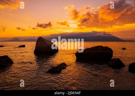 Tramonto caldo sulla spiaggia e mare tranquillo a Florianopolis, Brasile Foto Stock