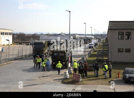 Bundeswehr Heavy Equipment Transport Systems (HETS) che trasporta i carri armati americani di battaglia di Abrams M1 sono in scena per il movimento in avanti a Coleman Barracks, Germania il 7 marzo 2022. La Bundeswehr lavora fianco a fianco con i partner americani per sostenere il programma di scorte preposizionate dell'esercito, per assicurare i nostri alleati e scoraggiare l'aggressione russa. (STATI UNITI Foto dell'esercito dello staff Sgt. Jesse Pilgrim) Foto Stock