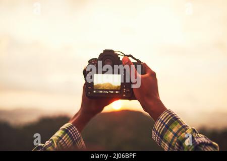 Visualizzazione della bellezza delle nature attraverso un obiettivo. Primo piano di un uomo non identificabile che scatta una foto su una fotocamera esterna. Foto Stock