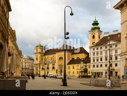 Vista della chiesa cattolica medievale di Schottenkirche e del monastero di Schottenstift in piazza Freyung a Vienna in nuvoloso giorno d'inverno, Austria Foto Stock