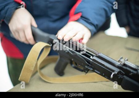 Assemblaggio del fucile d'assalto AK 47. Armi da fuoco Kalashnikov fucile d'assalto. La gente sta raccogliendo la pistola dummy. Addestramento militare. Foto Stock
