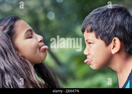 Due piccoli operatori. Sparato di un fratello e di una sorella giovani che si stuzzicavano mentre suonavano all'esterno. Foto Stock