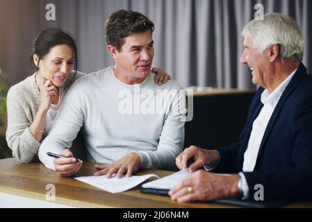 La sicurezza del futuro inizia ora. Scatto di una riunione di coppia giovane con un consulente maturo. Foto Stock