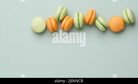 Vista dall'alto Macaroon a due colori isolato su colore Mint. Dimensione banner con spazio di copia per testo, ricetta o annuncio. Fuoco selezionato. Foto Stock