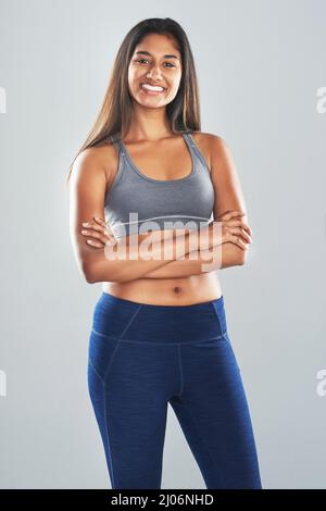 Ive ha lavorato sodo per raggiungere il corpo che voglio. Ritratto in studio ritagliato di una giovane donna attraente che si posa su uno sfondo grigio. Foto Stock