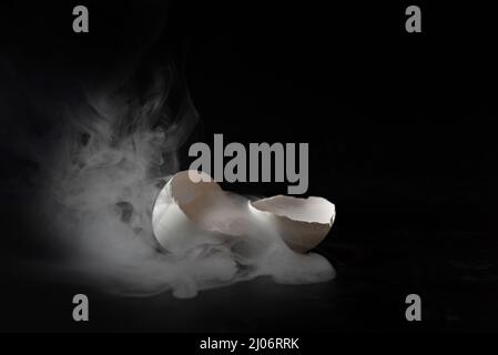 Il fumo esce da un uovo rotto. Foto Stock