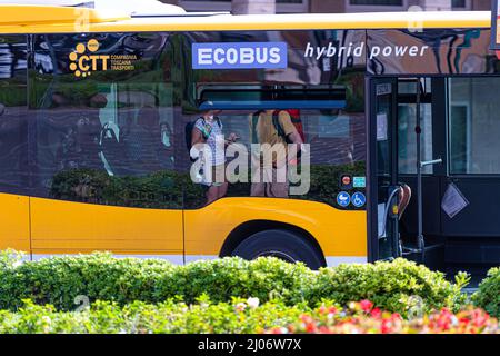 Pisa, Italia - 10 agosto 2021: Riflessioni di strada nelle finestre degli autobus ibridi pubblici ECOBUS Foto Stock