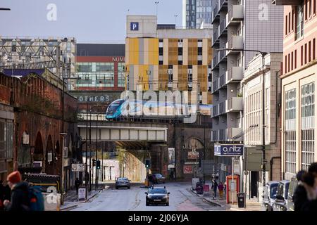 Scena stradale Whitworth Street Manchester, treno TPE sopraelevato attraverso il centro della città Foto Stock