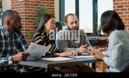 Il lavoratore dispiaciuto è stato licenziato da un gruppo multietnico di persone, sentendosi triste per la perdita di lavoro e di carriera. Dipendente femminile che si sente arrabbiato per fallimento, perdere lavoro e essere dimesso. Foto Stock